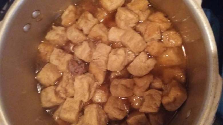 飞豆腐猪蹄冻,从电饭煲压力锅倒入压力锅,投入飞豆腐烧开,转中火烧至每个油飞豆腐吸入汤汁。