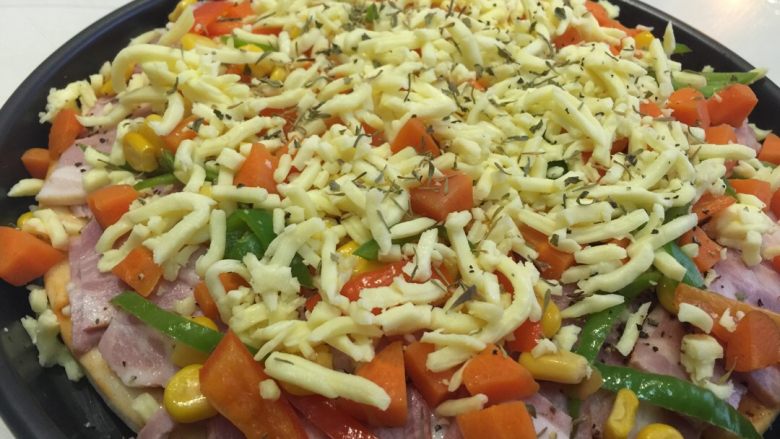 培根披萨,披萨盘底扫一层油（可以用黄油，我用的橄榄油），然后铺上面饼，面饼上均匀涂抹一层番茄酱，再铺满满一层芝士碎，依次放入培根（我会在培根上撒点黑胡椒）、炒好的胡萝卜等，再铺满满一层芝士碎，然后撒点调味料（黑胡椒百里香等）