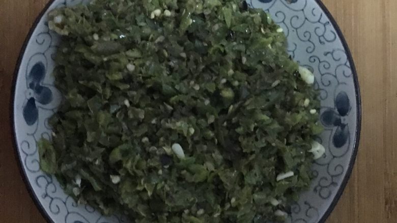 剁椒皮蛋,煎好的美人椒放置菜墩上冷却几分钟后，加入大蒜炖碎，放入盘中