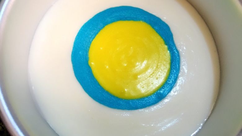 炫彩酸奶慕斯,白色慕斯倒入模具中,蓝色从慕斯糊中间倒入轻轻镇动使其扩散
同样的方法倒入黄色慕斯液