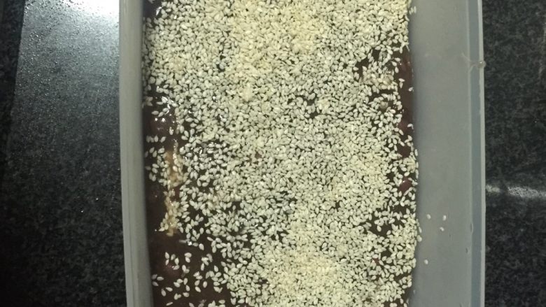 自制红米豆糕,碗底撒匀芝麻,倒入煮好的<a style='color:red;display:inline-block;' href='/shicai/ 3607'>红豆</a>浆,面上再撒上芝麻,如图