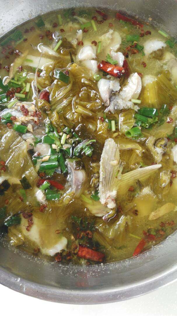 酸菜鱼,热锅冷油,放葱段,姜片,炸至金黄,放入鱼骨和鱼头,翻炒,加入料酒,翻炒,加水煮7-8分钟,倒入大盆备用,