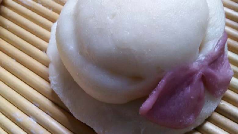 花样面食集合了,取适量面分成三份,圆形和长条状,一块圆型稍微按扁,一块擀成圆片,叠在一起,把长条围在帽子周围,用一点面团做成蝴蝶结放在接头处