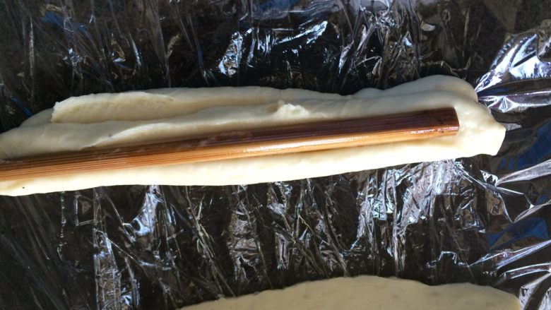 油条#挑战鸡蛋的100种做法#,两条叠在一起,用木条在中间按下,在面条两端捏一把,为了炸时不分开,(油条不分家的)