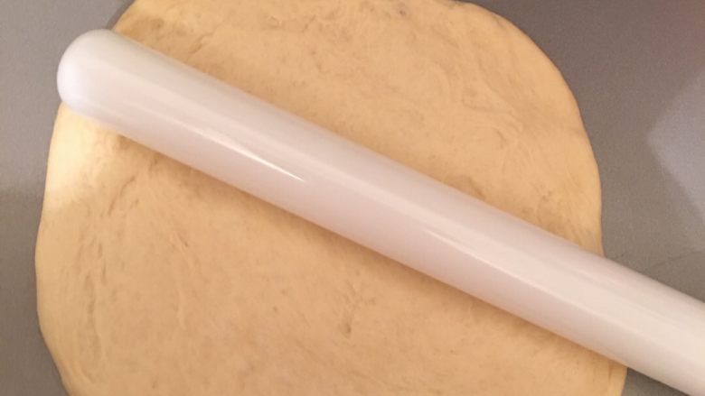 香肠芝士披萨,将面团用木棍推成饼底雏形。