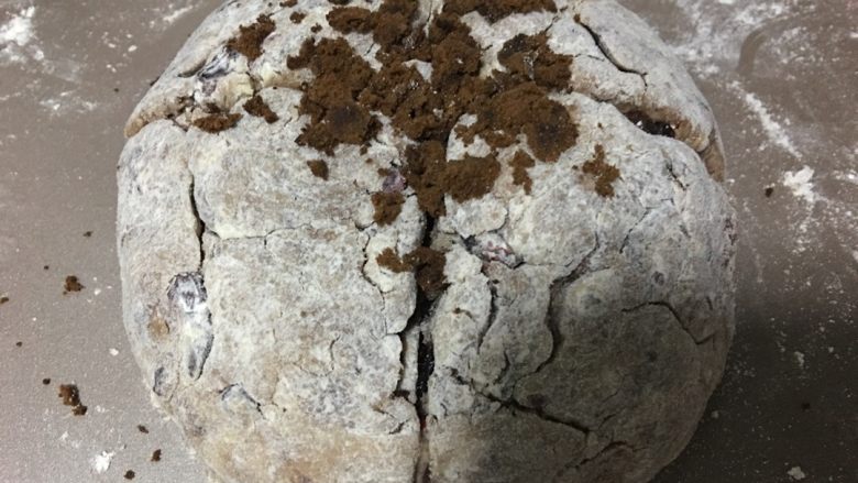 全麦苏打面包,我直接把这坨面抓到了不沾烤盘上，面上撒上一层全麦粉，用手团成团，略按扁，成半圆形，用刀切十字口，不用切到底，切一半多点，上面我撒了一点红糖，其实不用也可以了，静置十分钟。
