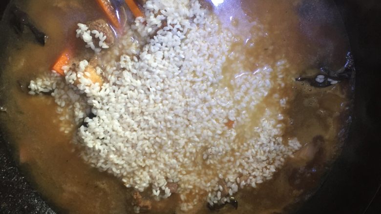 牛肉手抓饭,将米铺在菜上,加水没过米即可,水开后关小火慢慢将米饭蒸熟