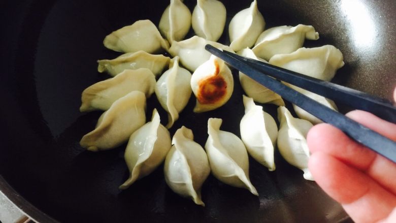 锅贴,煎至表面金黄时,加水至饺子三分之一处