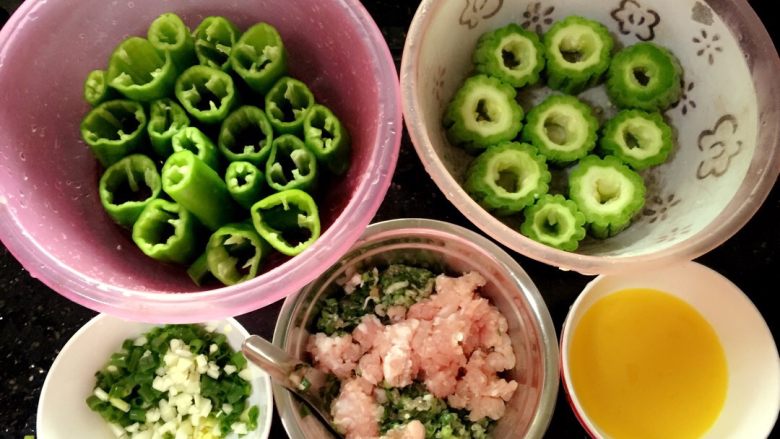 酿苦瓜➕酿辣椒,辣椒和<a style='color:red;display:inline-block;' href='/shicai/ 55'>苦瓜</a>切成一节节的。把中间的籽都挖掉。一会才有地方放肉肉。<a style='color:red;display:inline-block;' href='/shicai/ 3250'>葱</a><a style='color:red;display:inline-block;' href='/shicai/ 37'>姜</a>蒜切碎。打好蛋。将蛋放入肉末中。加入适量盐和酱油调味。(第一步处理肉是为了有一定的时间研制。更入味哦！）☺️