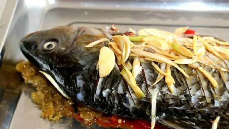 剁椒鱼头,鱼肉切口出塞进姜片，准备腌鱼🐠。