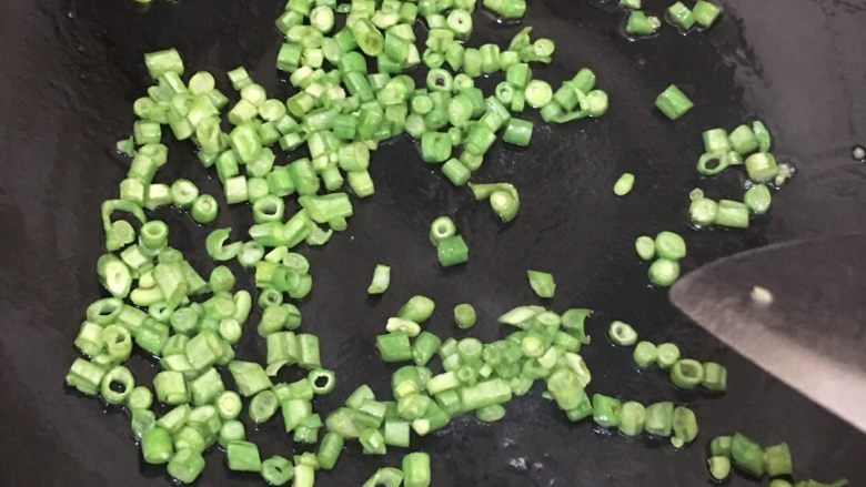 长豆角炒鸡蛋,锅里放少许油,把豆角丁炒至七分熟