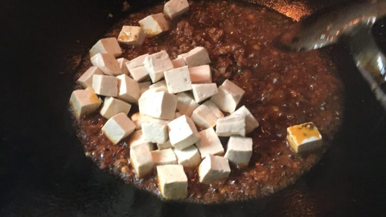 麻婆豆腐,炒均匀了后加入海椒面，可以根据你的颜色来看加多少辣椒面，颜色淡可以多加点，炒散后倒入豆腐，再加点少量的水，最后调味加入适量的盐，味精，鸡精，最后沟点淀粉，起锅撒上花椒面，葱花，就完成了