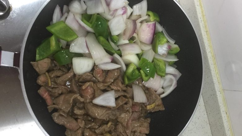 青椒洋葱炒牛肉,牛肉炒至8成熟时,把之前过油的青椒洋葱放入锅中,翻炒至牛肉全熟,放盐调味即可。