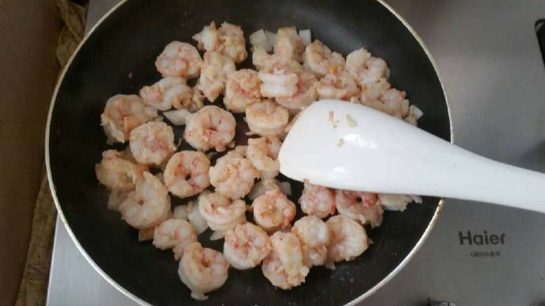 石锅芝士海鲜拌饭,下入虾仁,爆火炒至变色。