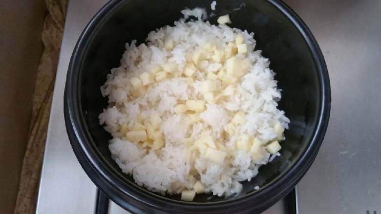石锅芝士海鲜拌饭,放入米饭,米饭上再撒一层芝士碎。