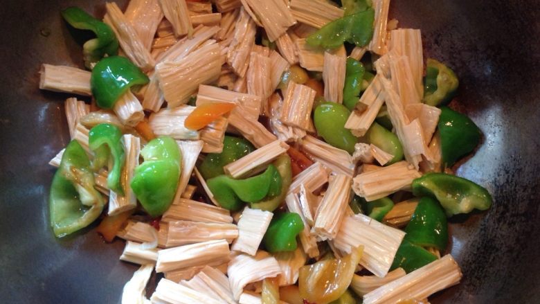 腐竹炒青椒,倒入腐竹，加入适量的盐，味精，少许水，生抽，继续翻炒