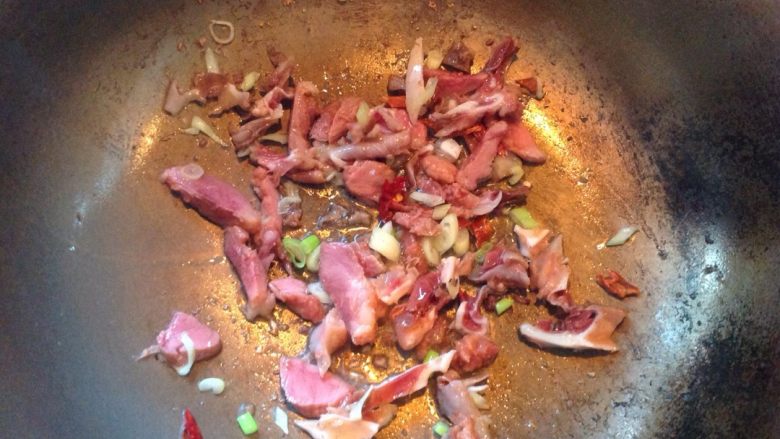 长豆角炒猪脆骨,倒油,爆锅,倒入猪脆骨,翻炒几下
