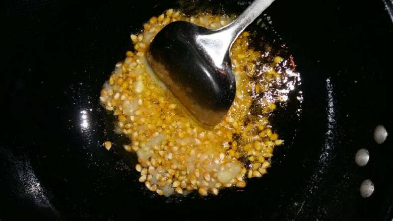 爆玉米花,黄油倒入锅内用中小火至融化,放入玉米和冰糖粉慢慢翻炒。