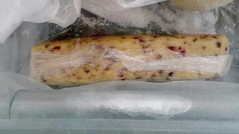 蔓越莓奶香饼干,团好面,包上保鲜膜,整形放入冰箱。有工具的可以用工具,我没有所以我是用手隔着保鲜膜整的型。