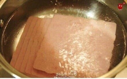 鸡蛋液土司,把切片火腿放进开水里焯一下,这样可以煮熟火腿,也可以去掉一些油分