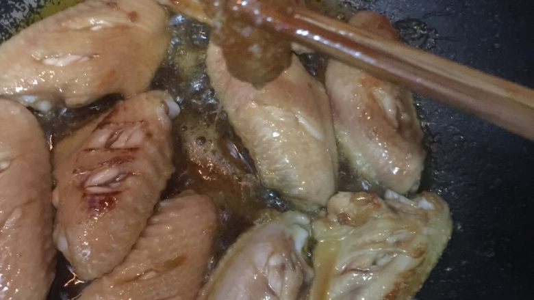 红烧鸡翅,放鸡翅在锅里炒。 大家可以看一下糖熬好后是这个样子的