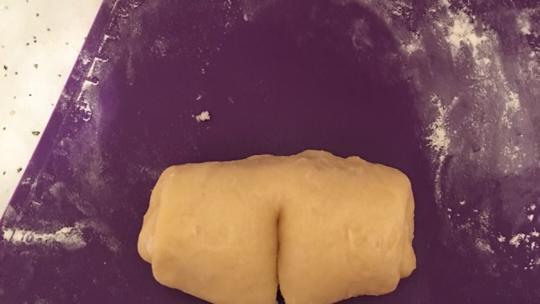 椰蓉馅奶香面包,然后在卷好后的椰蓉面团上,中间部分划一刀