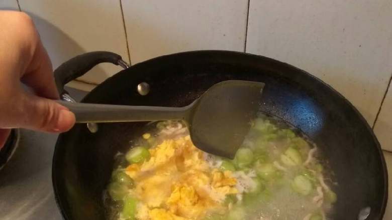 丝瓜毛豆肉丝蛋汤,水煮开后,下蛋片。搅拌一下。然后放适量盐。