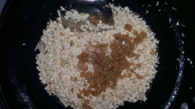 菜包子(萝卜豆腐),倒入豆腐丁适量的盐,肉油渣炒透。