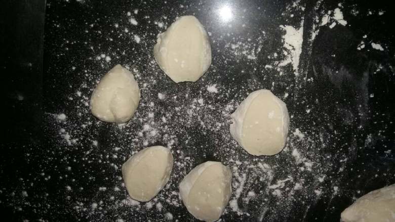 菜包子(萝卜豆腐),面团摁个小孔不回缩面团已经发好了,倒在案板上始终朝一个方向揉,两头叠加进来,继续揉两头叠进来继续揉,按这个揉法多揉几次,揉的越透不管馒头包子会蓬松柔软,再搓揉成长条,切成小剂子。