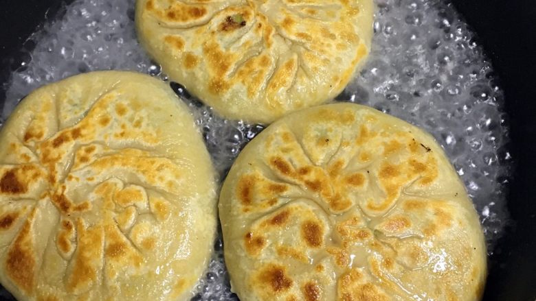 家常肉饼,两面金黄加适量水,中火加盖闷煮,这是保证饼成熟的关键步骤,待水烧干,不断翻饼来保证饼不会糊掉,待饼的水煎干在翻两次即可
