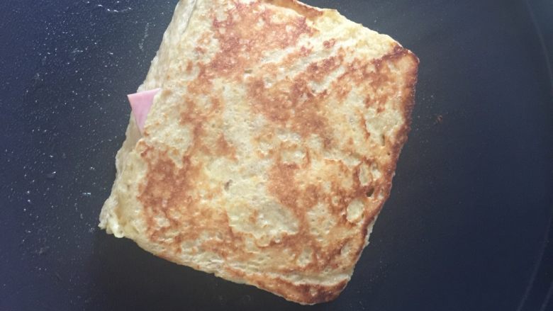 蛋奶西多士,电饼档（平底锅）加橄榄油，煎至金黄则翻面。两面都呈金黄色即可