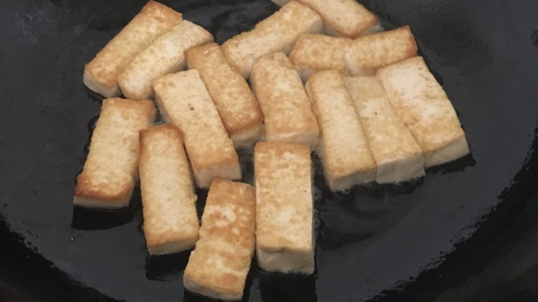番茄虾仁豆腐,热锅倒油 油热开小火煎豆腐 煎至两面金黄 捞出备用