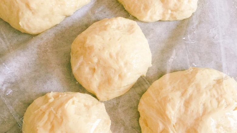 鸡蛋牛奶排包,分成若干份（尽量相同克数哦，我是因为家里小盆友一直打闹就速度分成这几个小面团）盖上保鲜膜，松弛20分钟左右！