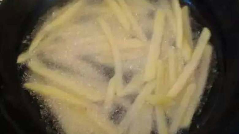 薯条,在锅中放入适量食用油,将土豆条炸至金黄色。