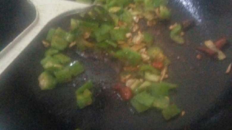 秘制辣炒鸡块,锅里热油,放入少许孜然粉,辣椒粉,碎辣椒,蒜,翻炒出香味,放入青椒翻炒