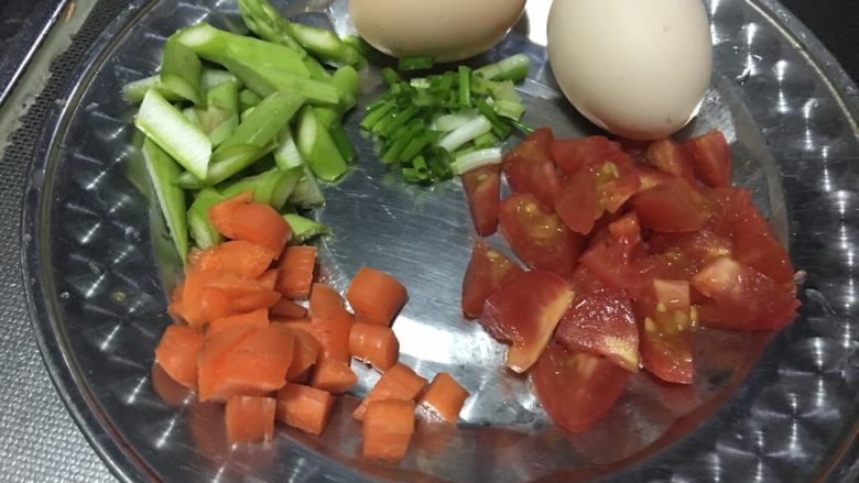 「吃货久久」做一碗颗颗分明好看美味的蛋炒饭,准备两个<a style='color:red;display:inline-block;' href='/shicai/ 60780'>土鸡蛋</a>，野生有机小胡萝卜相对易熟可以和<a style='color:red;display:inline-block;' href='/shicai/ 122'>芦笋</a>一起炒熟不需要焯水，而且和炒饭一起吃起来口感更好，也有营养。圣女果切丁