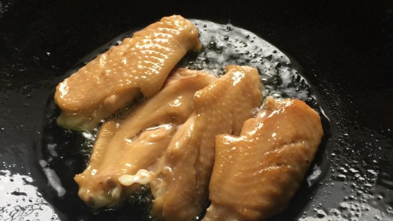 芝香可乐鸡翅,大火热锅放油,看到油温上升有点点声音就关小火,把鸡翅逐渐下锅煎