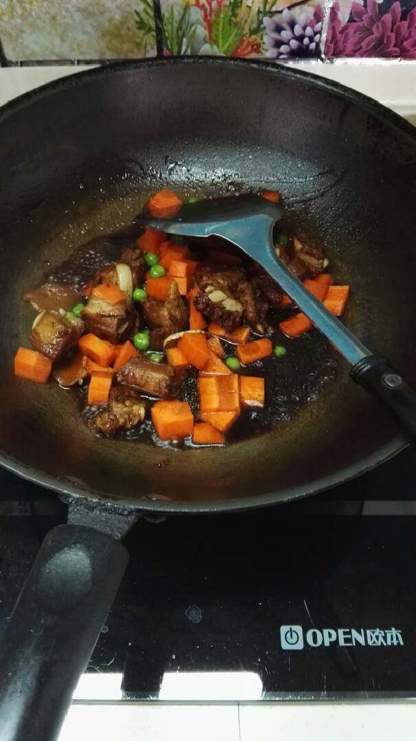 排骨闷饭,煮了大概20分钟后开大火,倒入胡萝卜丁和青豆一起翻炒收汁