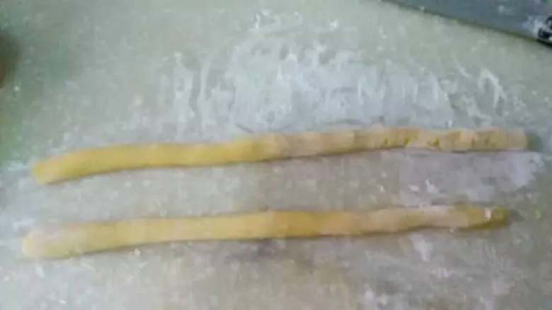 蜂蜜蛋果子,撒适量干粉防粘,将面团搓成手指粗细的长条形