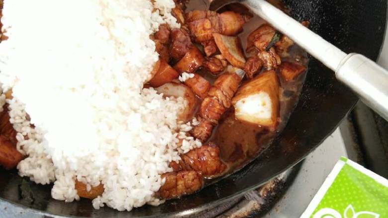 五花肉土豆块焖米饭,最后把淘好的大米放入炒锅,一起翻炒!直到颜色均匀!
