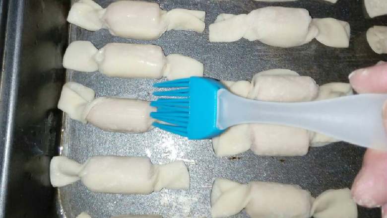 香肠味糖果,烤盘底部刷上油,糖果摆进烤盘后,每个糖果再刷上油