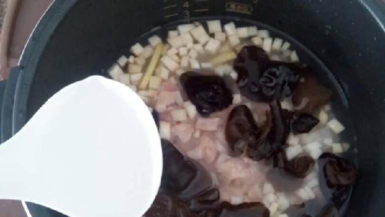 香菇木耳鸡肉粥,倒入3/2的水，盖上盖子，开始煮粥，等到水开了之后，加入适量的盐调味