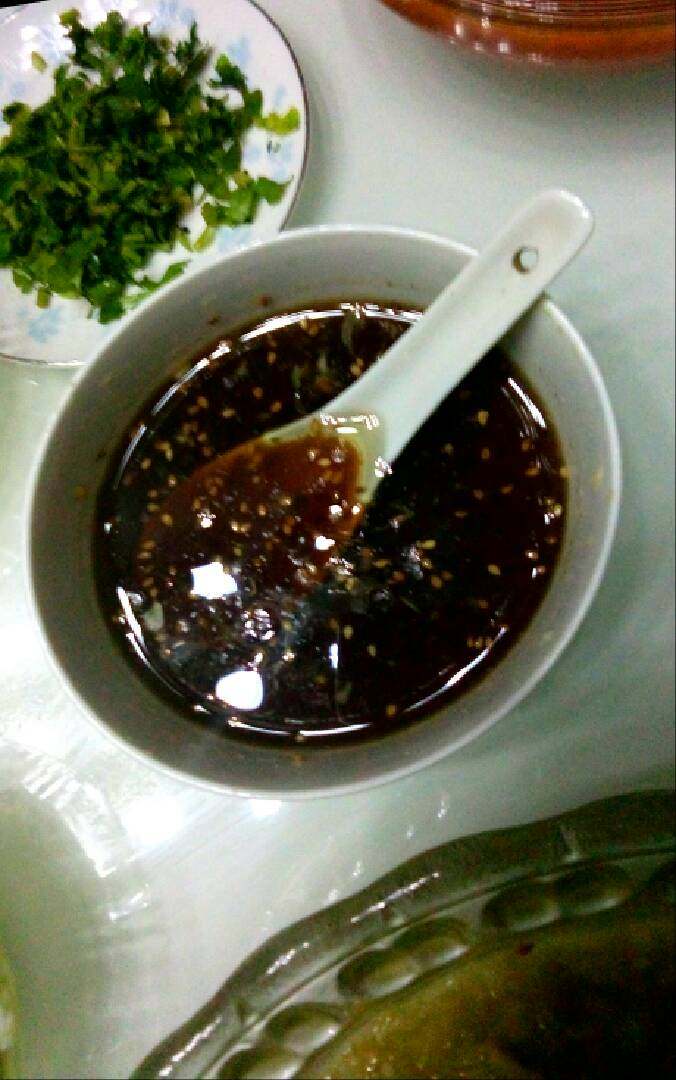 蒜泥茄子钢丝面,这步是勾兑汤汁,碗里放入少量淹制酸豆角汤(没有可以不放)在放入适量的醋、盐、鲜酱油,在放入呛好到芝麻油,放入味精,这样汤汁就做好啦