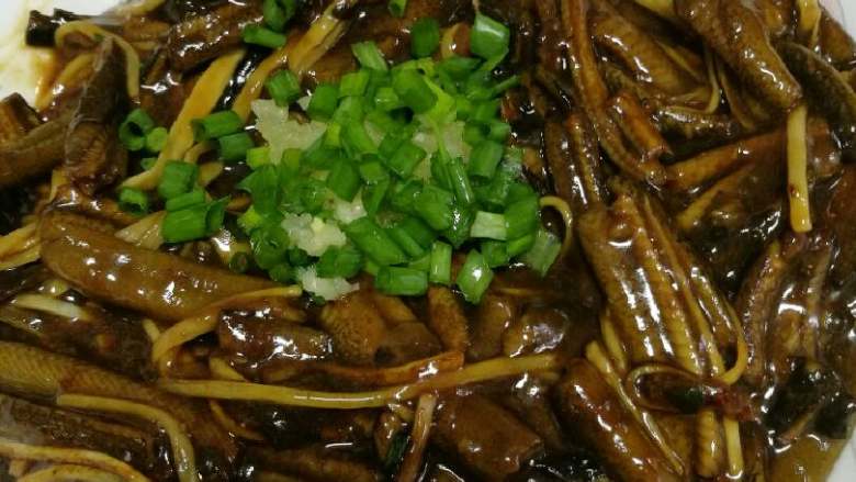 响油鳝丝,出锅盛在盘子里后,在中间挖个小凹坑,放入蒜泥和葱花,再撒点胡椒粉。