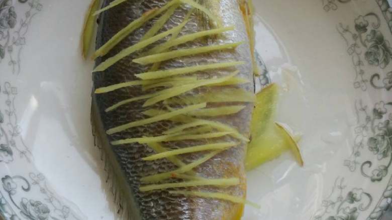 微波炉蒸鱼,鱼清理干净，用料酒抹一下，姜片铺盘子底部防止鱼皮粘住，剩下切成姜丝铺在鱼身，和塞鱼肚子里