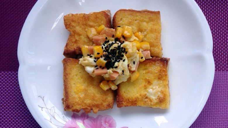 煎吐司块,吐司放下面，煎好蛋放上面。撒上芝麻。