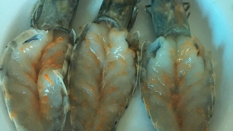 芝士焗虾,在虾肉上,撒上适量的盐,用手涂匀,再撒上蒜香粉,然后用手涂匀,按摩虾肉。涂好后,放置10分钟