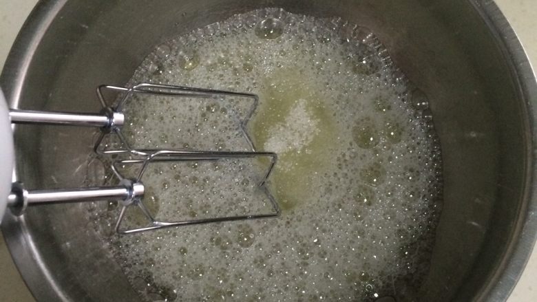 香蕉戚风蛋糕,用电动打蛋器把蛋白搅打至粗泡时,加入细砂糖搅打。