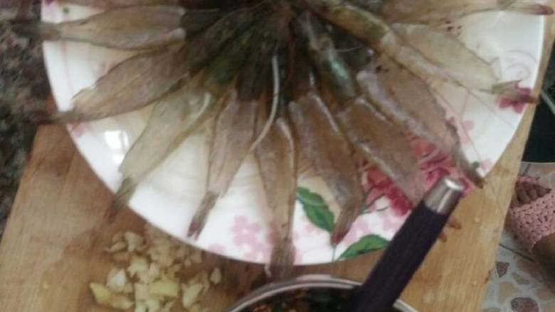 粉丝开背虾,拿一个小碗加入葱姜蒜末,酱油,四之五勺香油,一勺,辣椒油,花椒油适量。加入鸡粉。