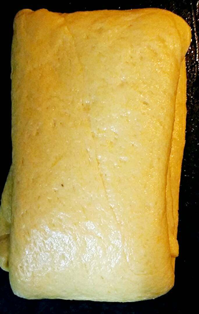 南瓜千层糕,继续用擀面杖擀薄,刷上油用折被子的叠法